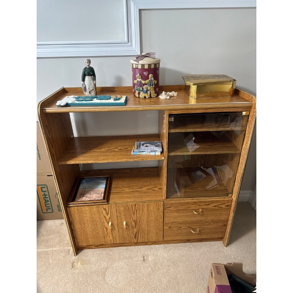 a rustic oak entertainment center with glass-front display shelves and lower storage cabinets.