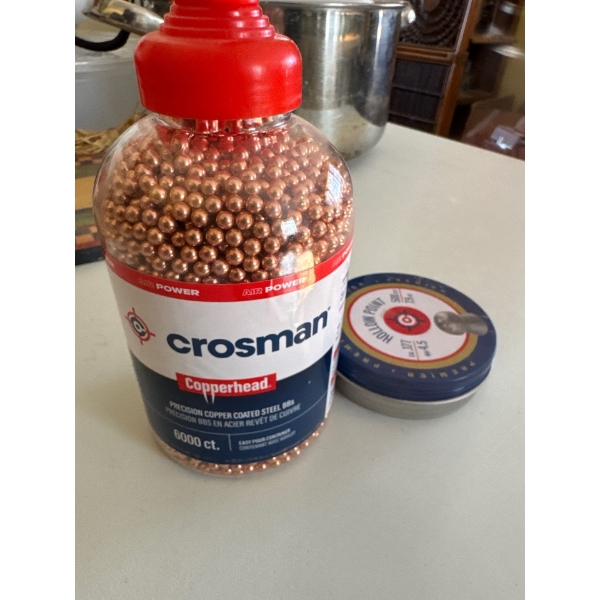 container of Crosman Copperhead .177 caliber BBs alongside a tin of pellets.
Product: Crosman Copper
