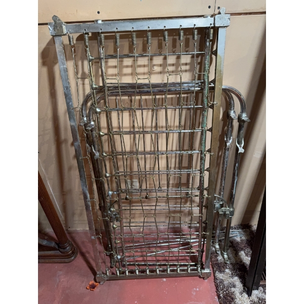Vintage baby crib with a metal frame and spring mattress support. The crib is designed with a classi