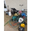 Image 1 : Various outdoor tools and garden equipment such as hoses, buckets, plastic containers, extension cor
