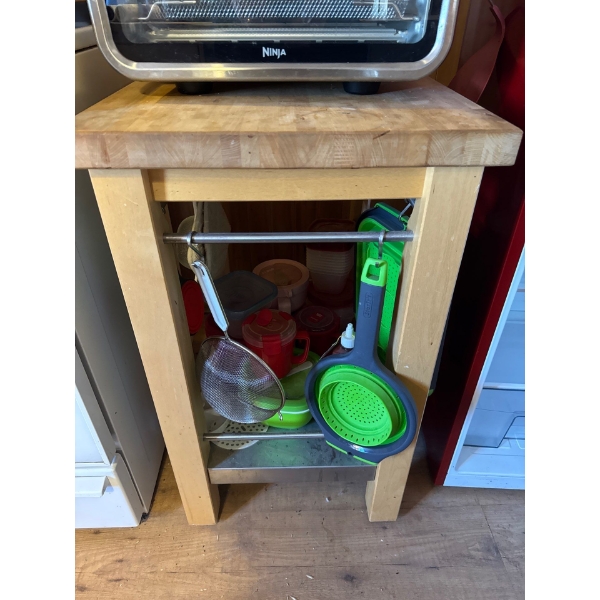 Movable wooden kitchen island or prep station with lower shelf. All kitchen supplies on the shelf in