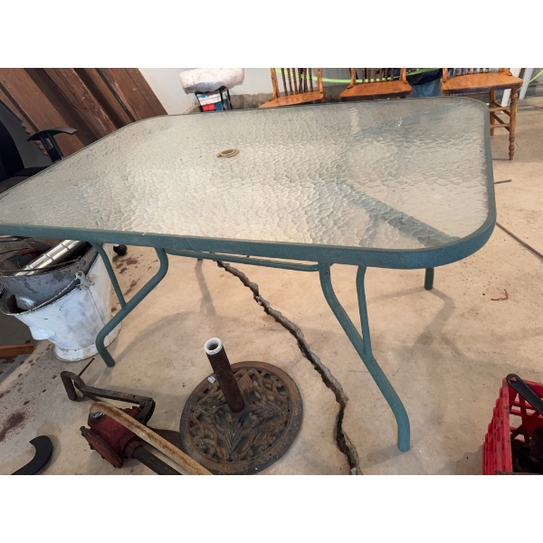 One rectangular glass-top patio table with a central umbrella hole and a metal frame, along with six