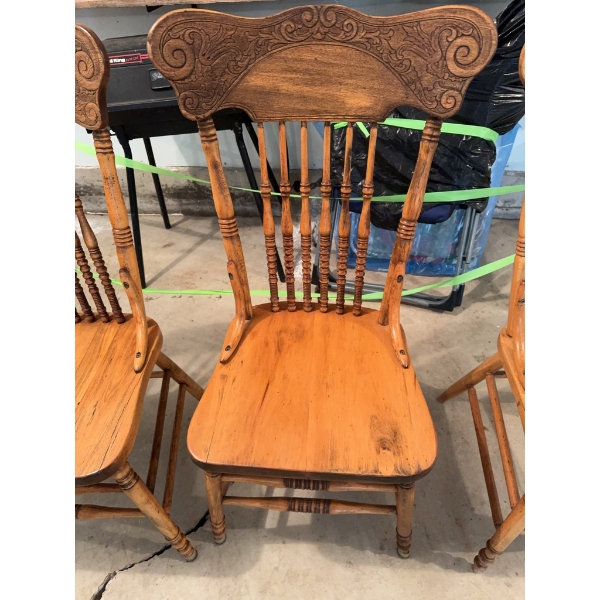 Set of three wood chairs with spindle backs and carved top rails, along with a large rectangular fol