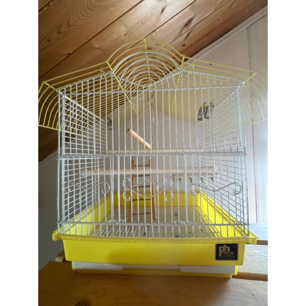 A Prevue Hendryx Small wired bird cage with yellow bottom and bird toys and features inside, it is 1
