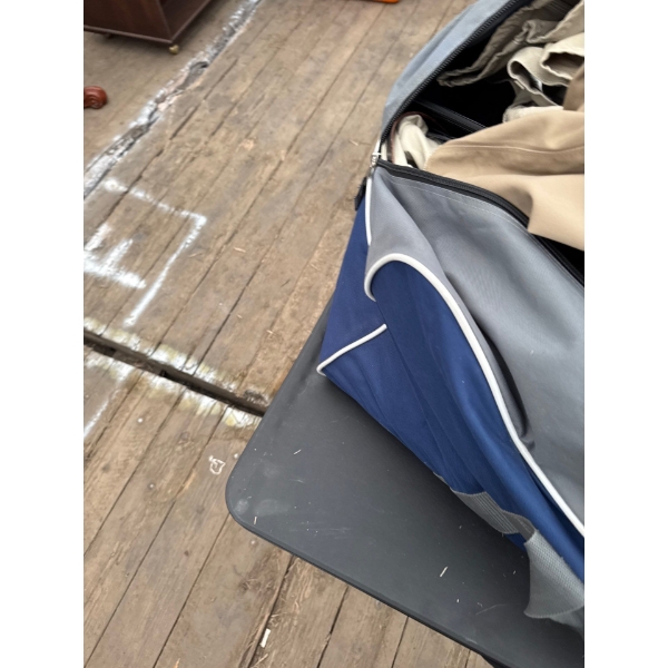 Full duffel bag of clothes, electronics, unknown items, and more.