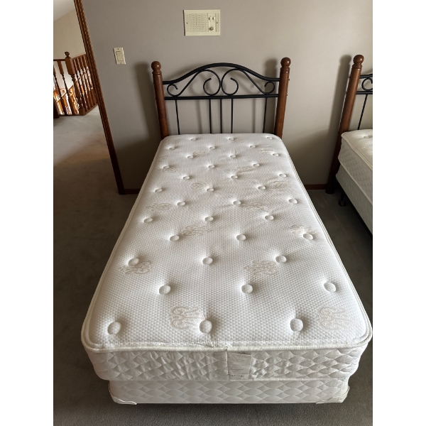  twin-sized mattress and box spring set with a classic black metal and wood bed frame.