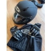 Image 2 : HJC full-face black motorcycle helmet with visor, a pair of Teknic armored gloves, and black leather