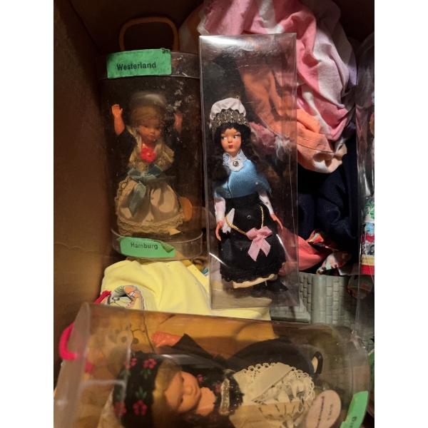 Several dolls in traditional German regional costumes, labeled "Westerland" and "Hamburg," housed in