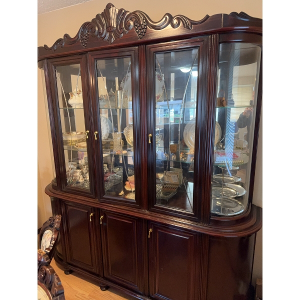 This mahogany china cabinet features glass doors, mirrored back, and interior glass shelving for dis