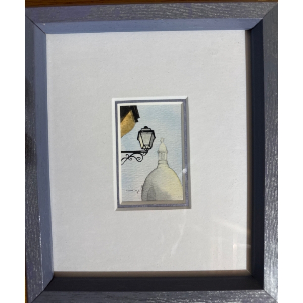  displays a framed original watercolor painting featuring a street lamp and a dome structure. 