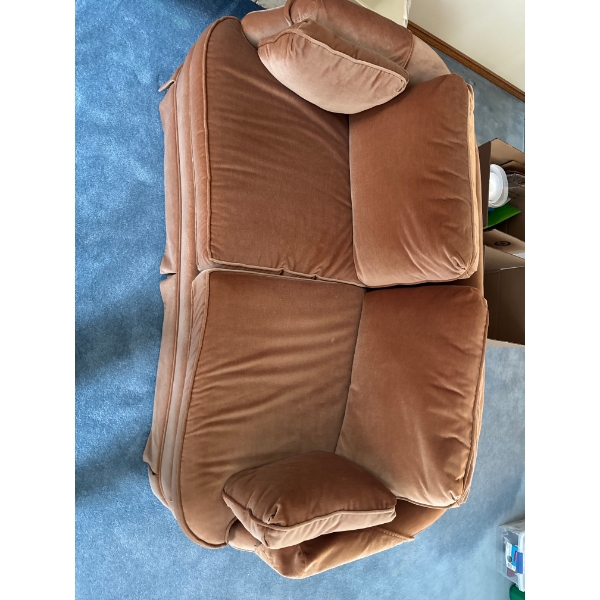 vintage-style loveseat upholstered in a rust or orange-colored velvet fabric. 