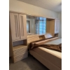 Image 4 : palisar wood bedroom wall unit featuring integrated wardrobes and a central headboard with a mirror.