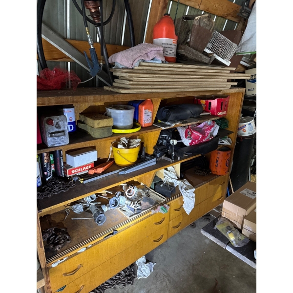 Shelving unit with chains, various items, chainsaw bar oils, camp fuels, unknown items in drawers. u