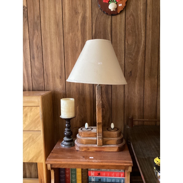 This is a dark metal candlestick holder with a thick, white, faux-wax candle 