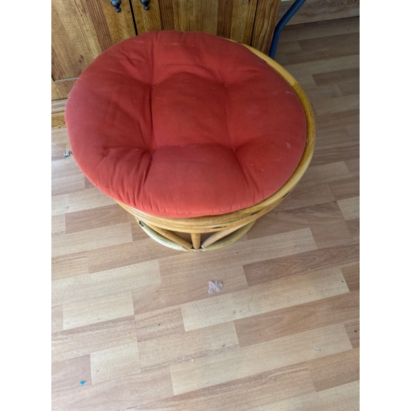 rattan papasan chair features a tufted red cushion and a sturdy woven base. 