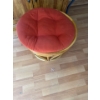 Image 1 : rattan papasan chair features a tufted red cushion and a sturdy woven base. 