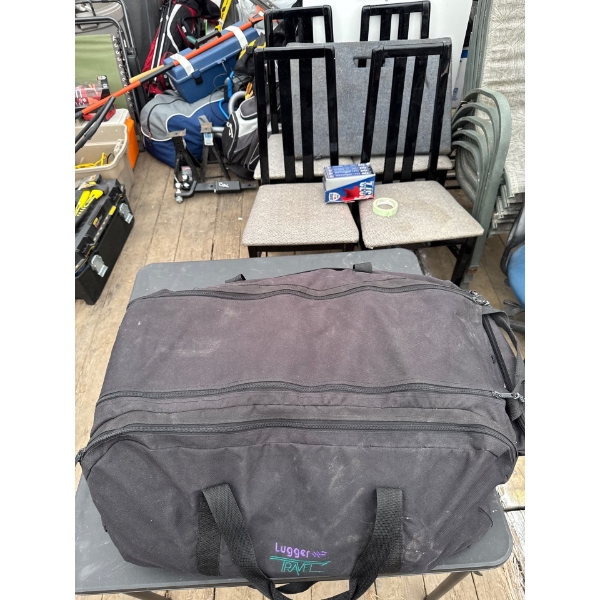 Duffel bag full of various clothes, unknown items, and more.