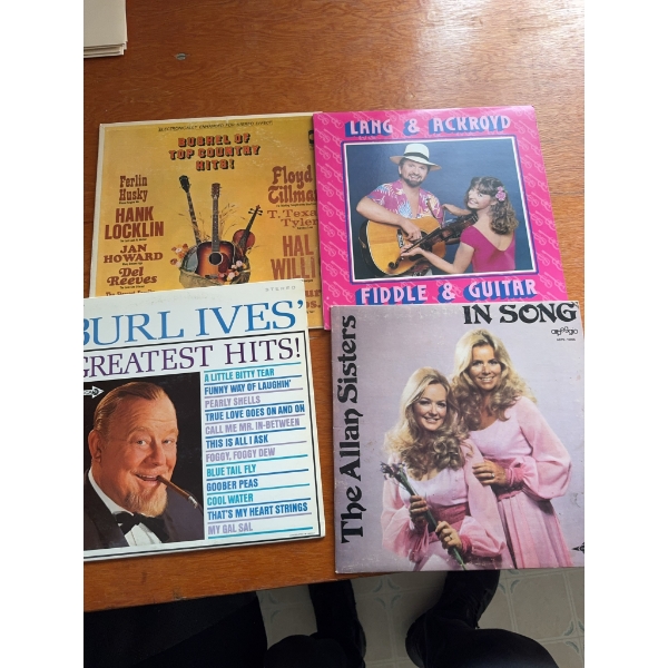 Four vinyl records featuring various country and folk artists: Top Country (various artists), Lang &