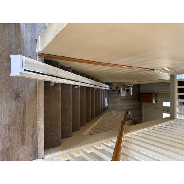 This is a straight rail stairlift, designed to help individuals with mobility challenges navigate st