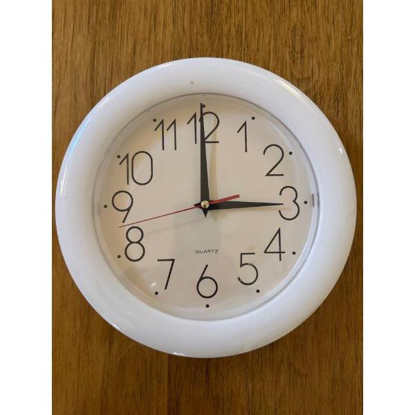white wall clock featuring a quartz movement.
