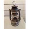 Image 4 : Metal Dietz kerosene lantern. The lantern shows signs of use and age and includes an attached wire h