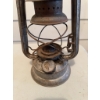 Image 1 : Metal Dietz kerosene lantern. The lantern shows signs of use and age and includes an attached wire h