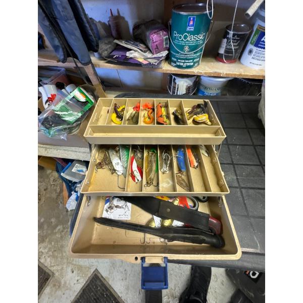 Fishing tackle box full of lures and knives, scissors.
