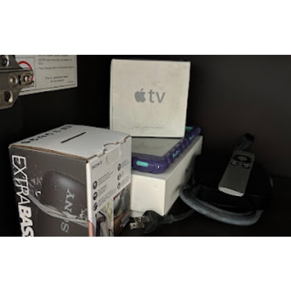 Sony Bluetooth portable speaker, an Apple iPad with a purple and green protective case, and accompan