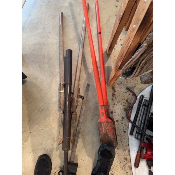 Multiple post hole diggers with wood and metal handles, a pair of long-handled red metal diggers, an