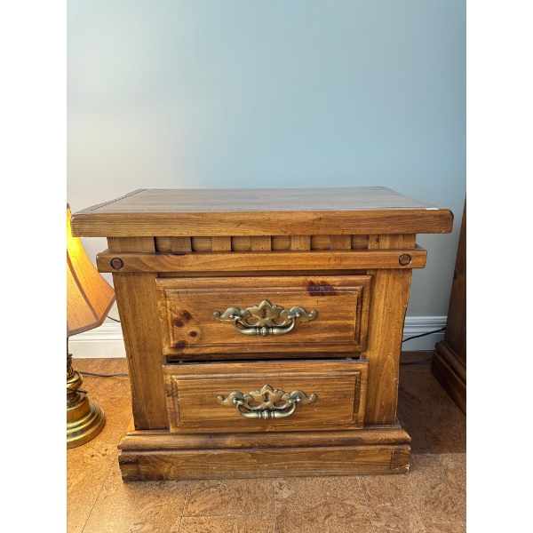  rustic oak two-drawer nightstand with brass drawer pulls.   