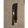 Image 1 : Tramontina hand-forged bolo machete, made in Brazil, featuring a wooden handle and green sheath. The