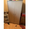 Image 2 : Wooden storage cabinet featuring double doors with metal handles. The interior includes shelving for