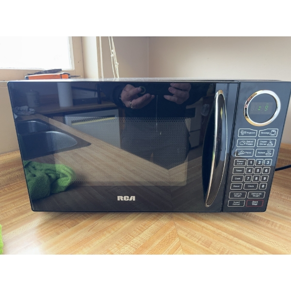 RCA brand microwave oven in black finish. Features digital control panel and turntable. Includes pre