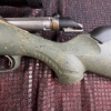 Image 15 : Ruger American bolt-action rifle chambered in 7mm-08 Rem. Features a green speckled synthetic stock,