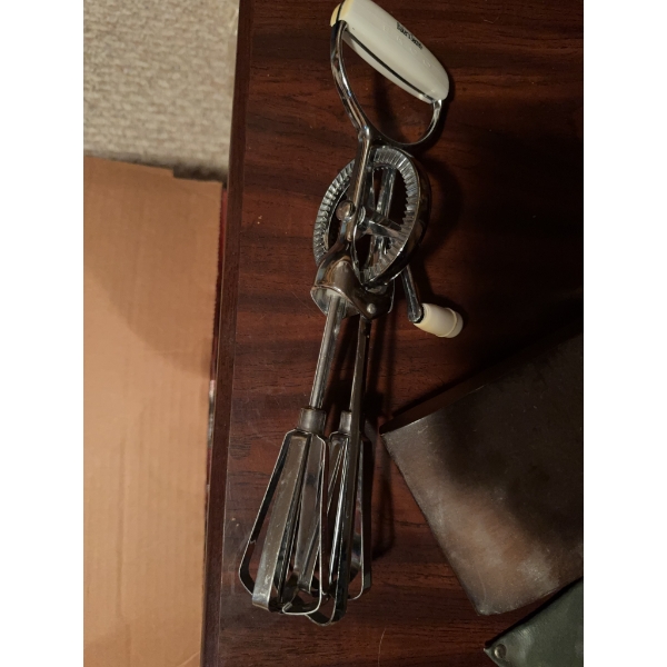 Variety of kitchen utensils, such as stainless steel egg beaters, kitchen knives with black handles,