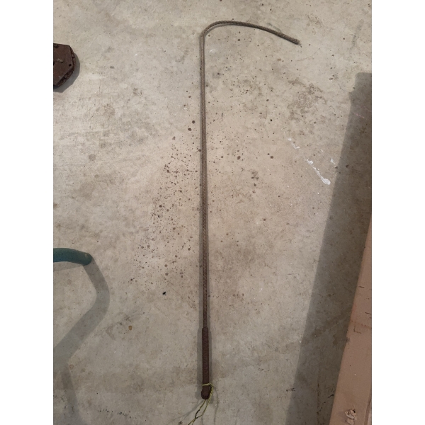 This item is a metal hay or bale hook featuring a straight metal shaft ending in a curved hook and a