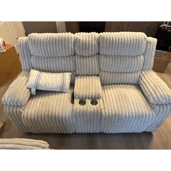 This is a corduroy reclining loveseat with a center console and cup holders.