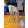 Image 1 : vintage clear glass Coca-Cola bottles featuring the iconic hobbleskirt contour design. 