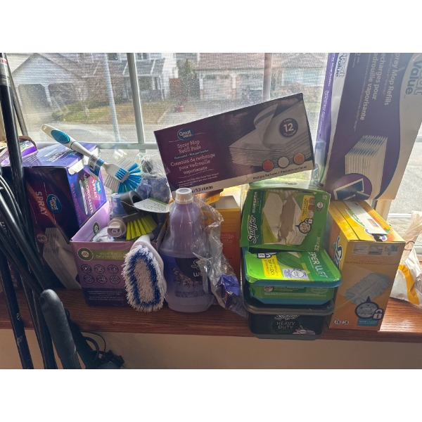 Cleaning supplies, including Swiffer mop, Swiffer duster,  new bottle of wetjet floor wash, couple o
