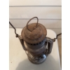 Image 2 : Metal Dietz kerosene lantern. The lantern shows signs of use and age and includes an attached wire h
