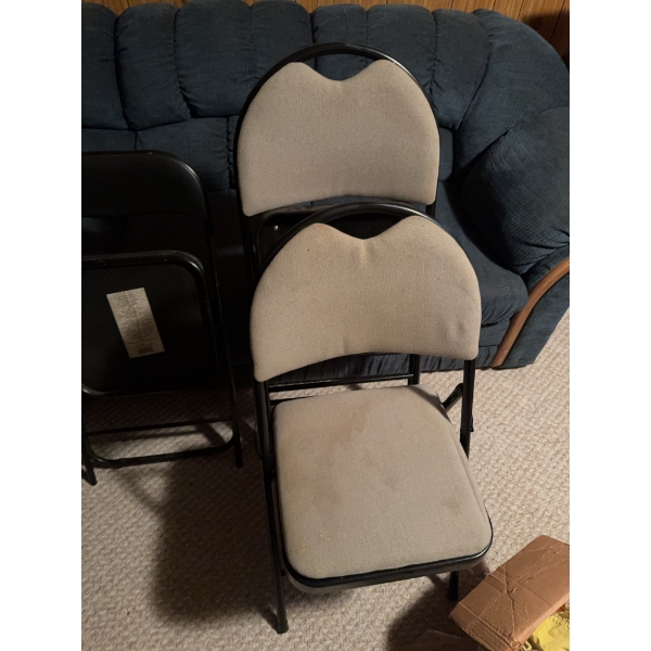 Four folding chairs including two with black metal frames and vinyl seats and two with black metal f