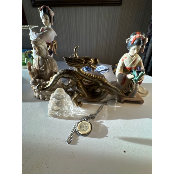 collection of various figurines, including a prominent brass or bronze dragon, a clear quartz or gla