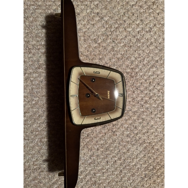 Junghans mantel clock with a wooden case and a geometric, angled face. Features gold tone hands, num