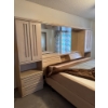 Image 2 : palisar wood bedroom wall unit featuring integrated wardrobes and a central headboard with a mirror.