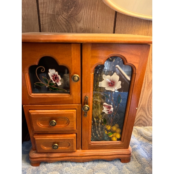 Vintage wooden jewelry box, , featuring an armoire style with a glass door and drawers. 
It has a li