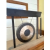 Image 1 : A Woodstock Chimes percussion desk gong. It features a bronze gong suspended from a contemporary bla