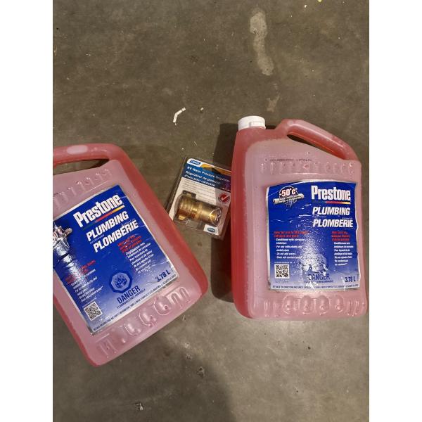 Two full jugs of RV antifreeze and an RV water pressure regulator