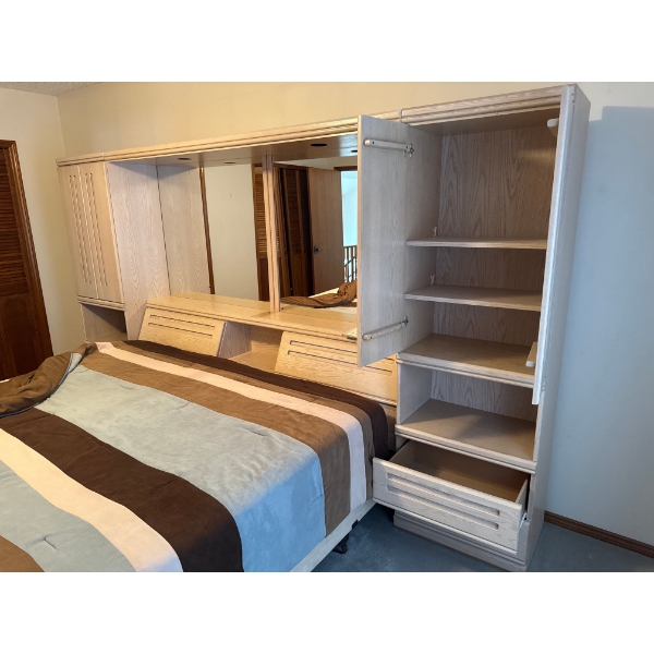palisar wood bedroom wall unit featuring integrated wardrobes and a central headboard with a mirror.