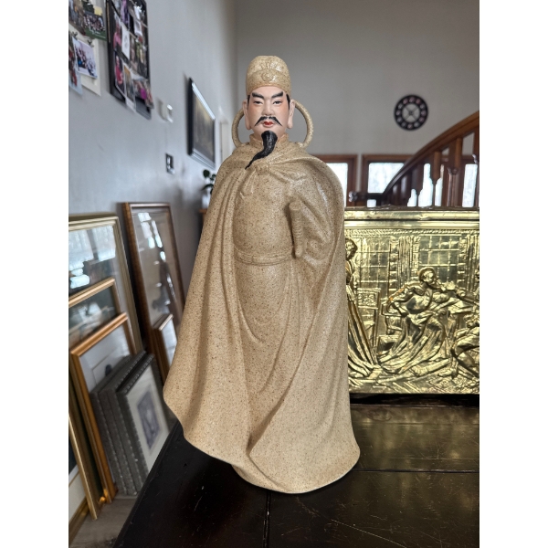 decorative ceramic or stoneware figurine depicting a historical or mythological Asian figure wearing